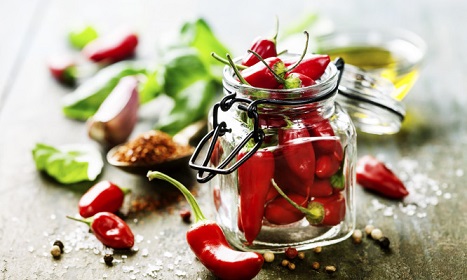 Red Hot Chili Peppers with herbs and spices over wooden background - cooking or spicy food concept